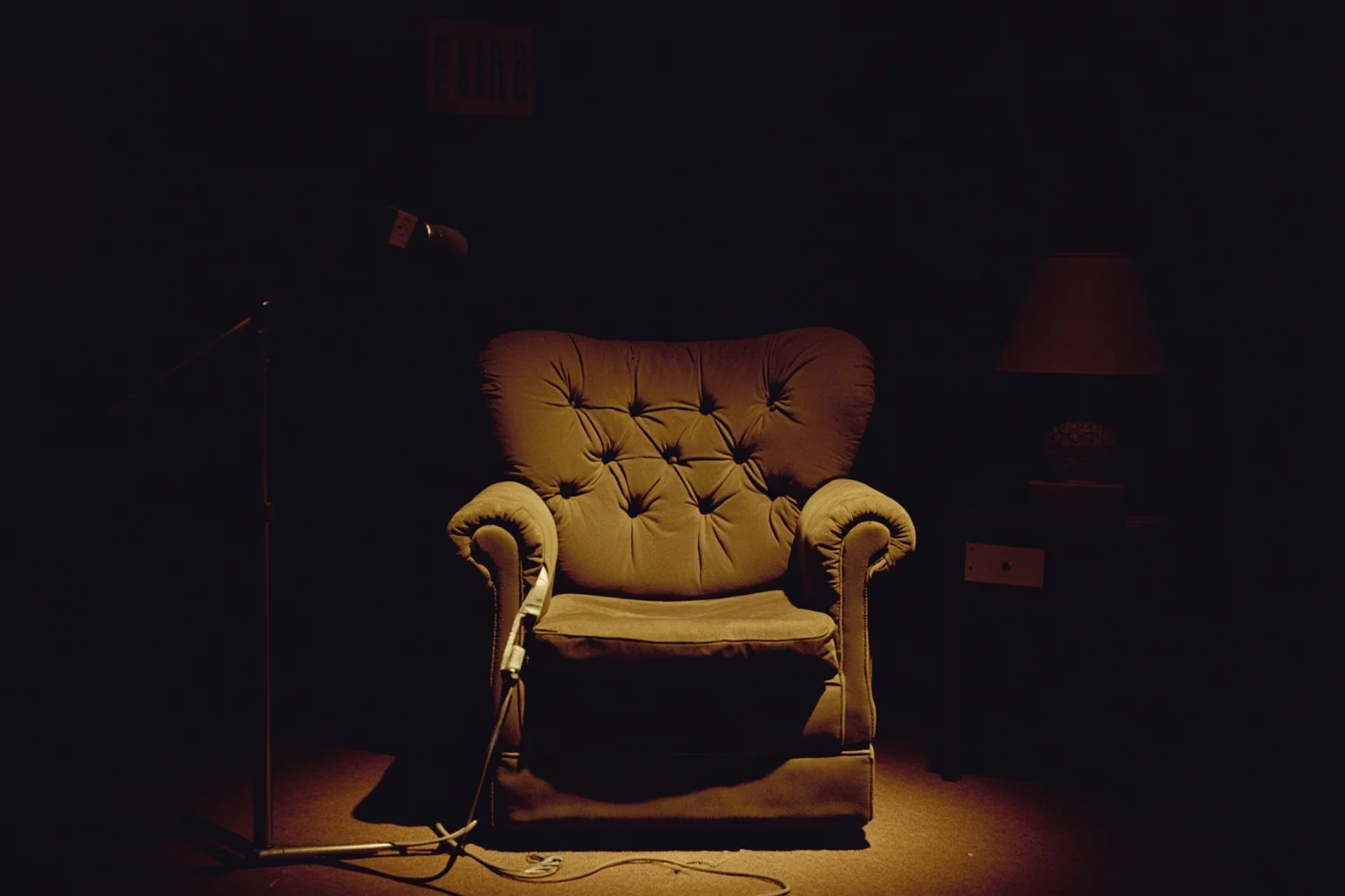 Things To Learn About The Beloved Princess Diana 14 A quiet interview setting with an empty armchair, a microphone, and a lamp, 1990s television studio aesthetic, no people.