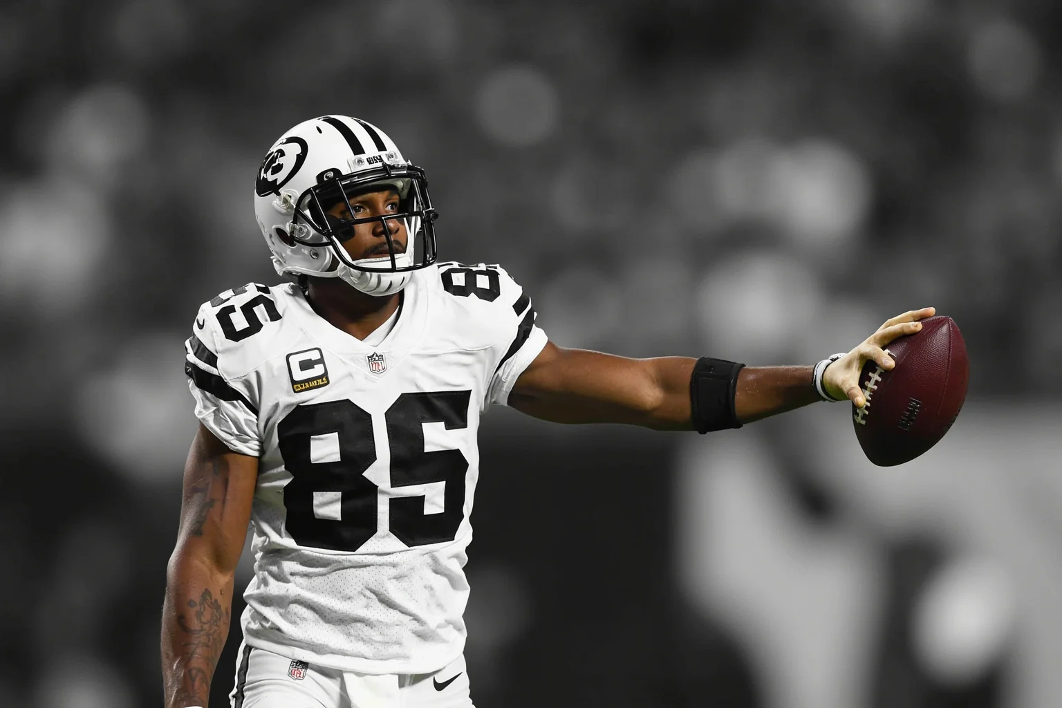 A receiver holding the football on the sideline after a legendary catch, generic uniform, no real logos or names, reflective mood.