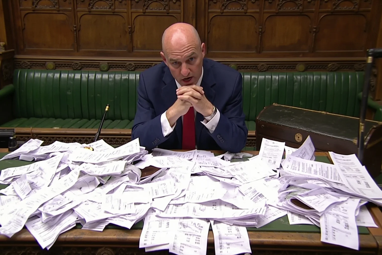 A scene of the British Parliament with an MP's desk covered in receipts for absurd items like moat cleaning and duck islands, representing the UK Parliamentary Expenses Scandal