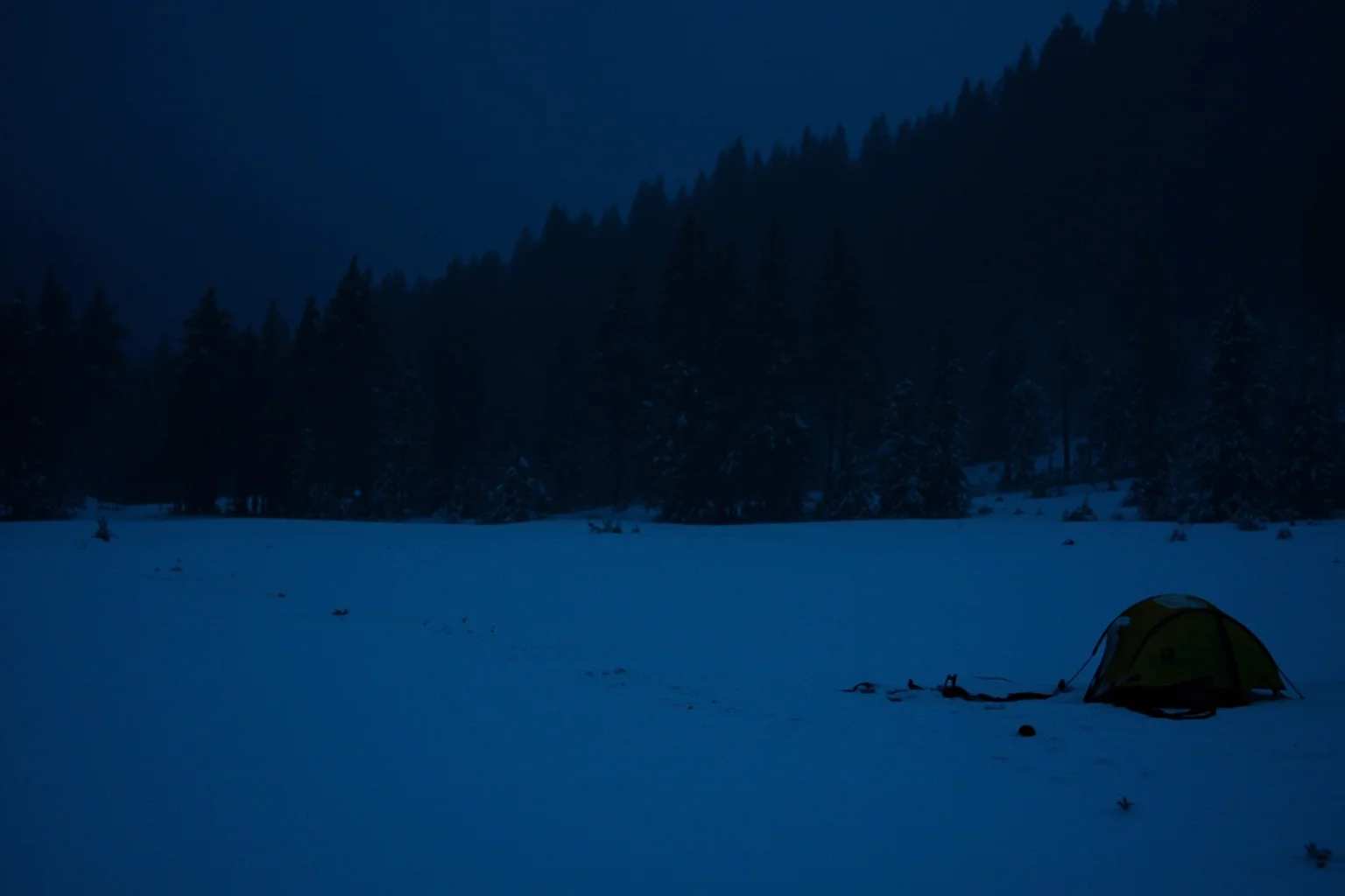 Scariest Missing Persons Cases in History: 20 Creepy Disappearances That Still Baffle Us 7 A snowy Ural Mountains campsite at night with a torn tent, footprints leading into the dark forest, cold blue tones, tense atmosphere.