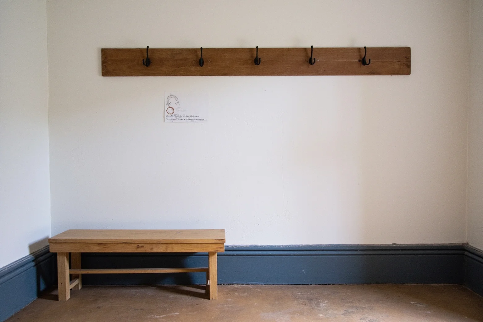 22 Famous Paintings That Were Stolen — Including 10 That Were Never Recovered 13 A tiny Dutch town museum with a single empty hook on a painted wall and a plain wooden bench, quiet and unremarkable setting, soft daylight, illustration.