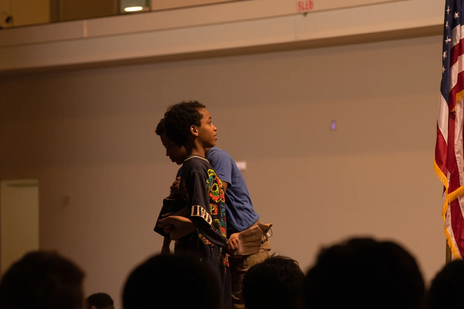 Things To Learn About The Beloved Princess Diana 23 A young person receiving a community service award on a small stage, viewed from the side, face not visible, warm lighting.