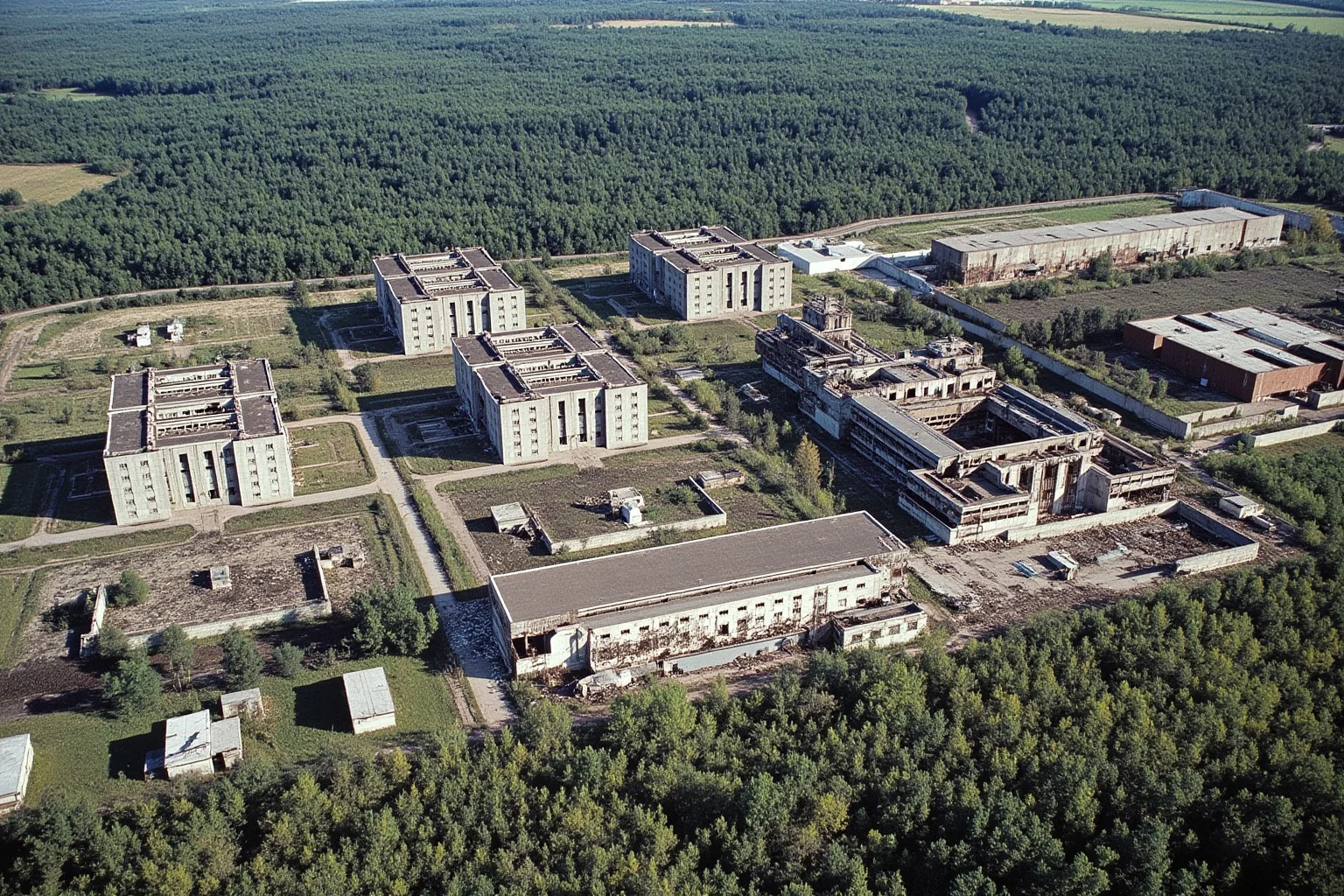 An aerial view of the Chernobyl power plant with three intact reactor buildings and one damaged, during the years when it still operated.