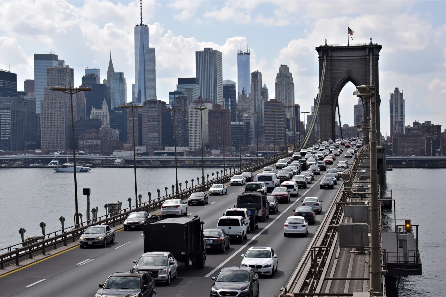 An aerial view of the George Washington Bridge with traffic cones blocking lanes and cars backed up for miles, with the Manhattan skyline in the background, representing Bridgegate