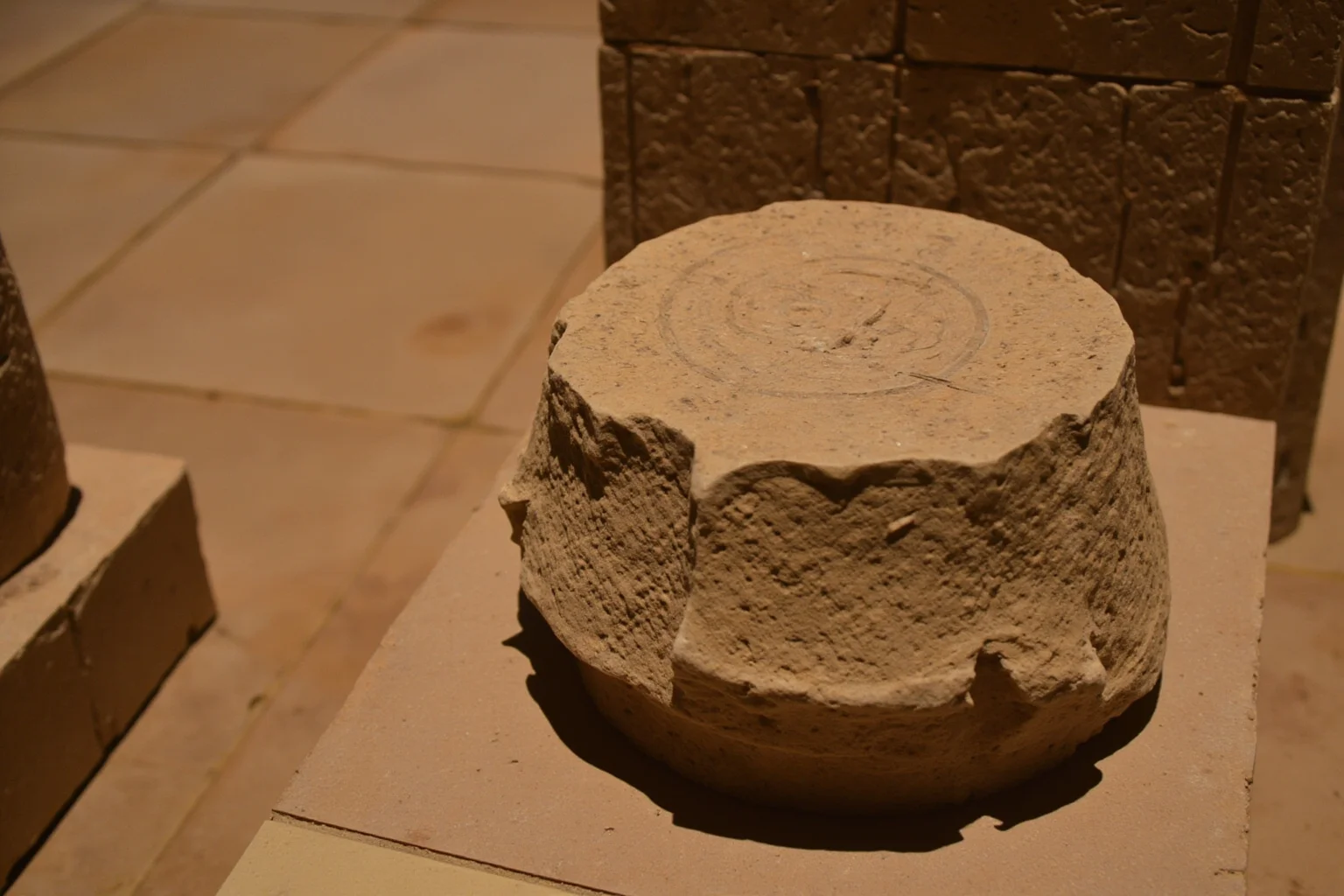 An ancient Egyptian stone water clock with markings, in a temple setting