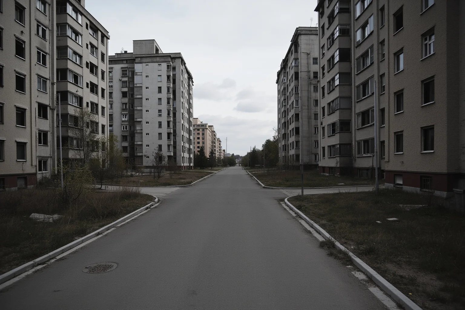 An empty Soviet-era city street with abandoned apartment buildings and an eerily quiet atmosphere, representing Pripyat before evacuation.