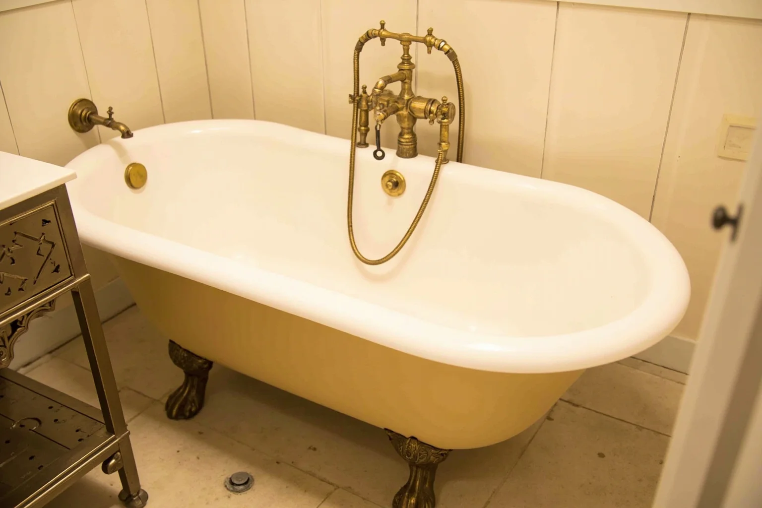 An old clawfoot bathtub with brass fixtures in a historic White House-style bathroom, no people.