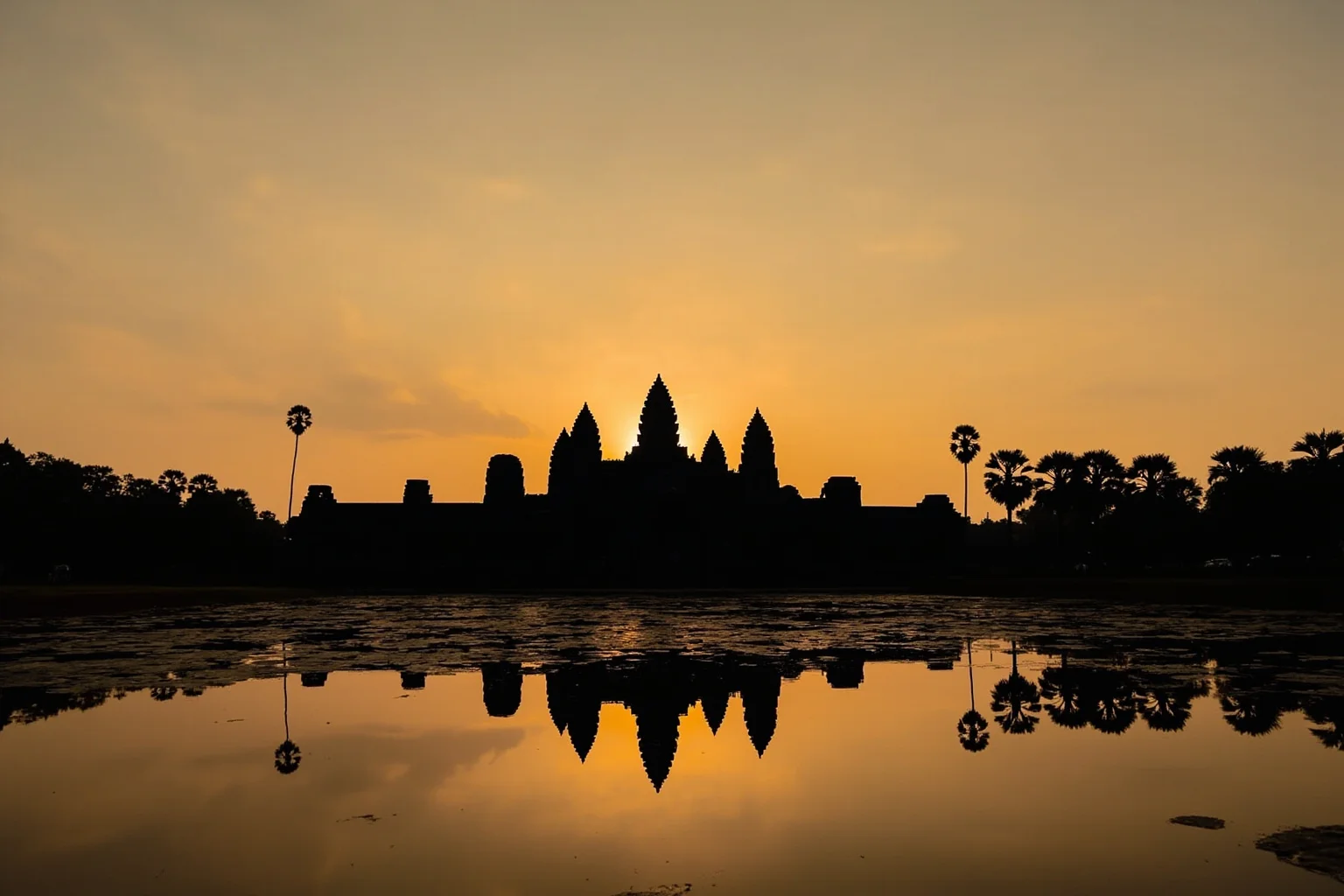 Angkor Wat's five towers reflected in a lily pond at sunrise, Cambodia
