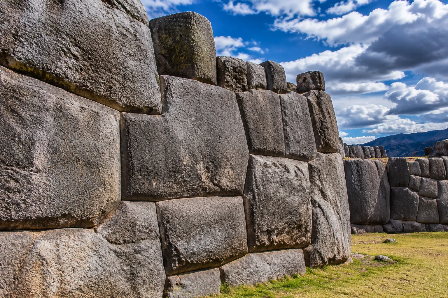 23 Historical Finds That Reveal Advanced Ancient Civilizations 5 Close-up photograph of the massive mortarless Inca stone walls of Sacsayhuamán, irregular limestone blocks fitting perfectly together, dramatic Andean sky behind, no people.