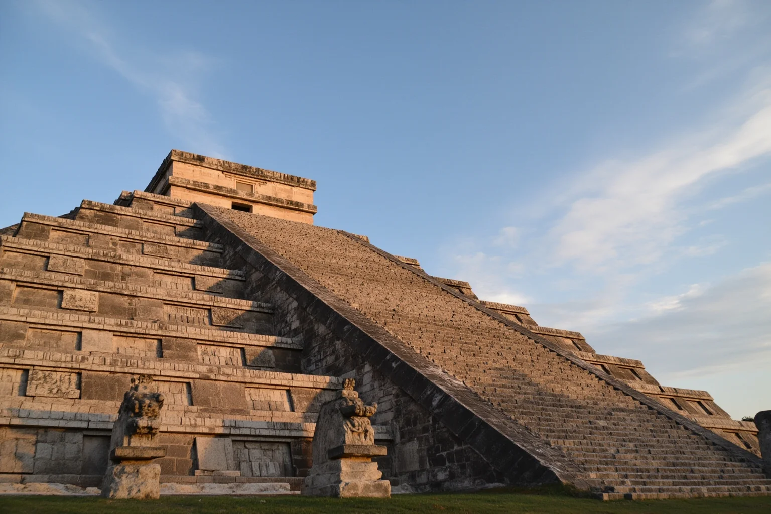 El Castillo pyramid at Chichén Itzá in late afternoon light with carved serpent heads at the stairway base