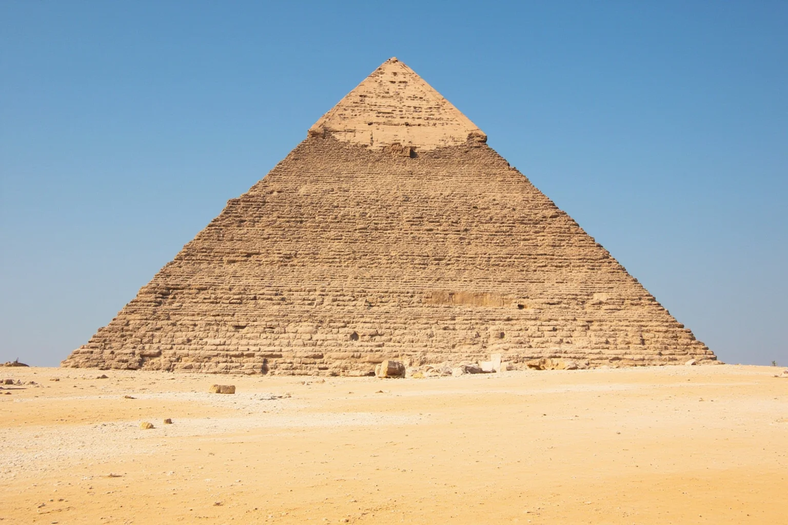 22 Oldest Monuments Found Around the World 19 Great Pyramid of Giza against a clear desert sky, showing the massive limestone structure from a low angle